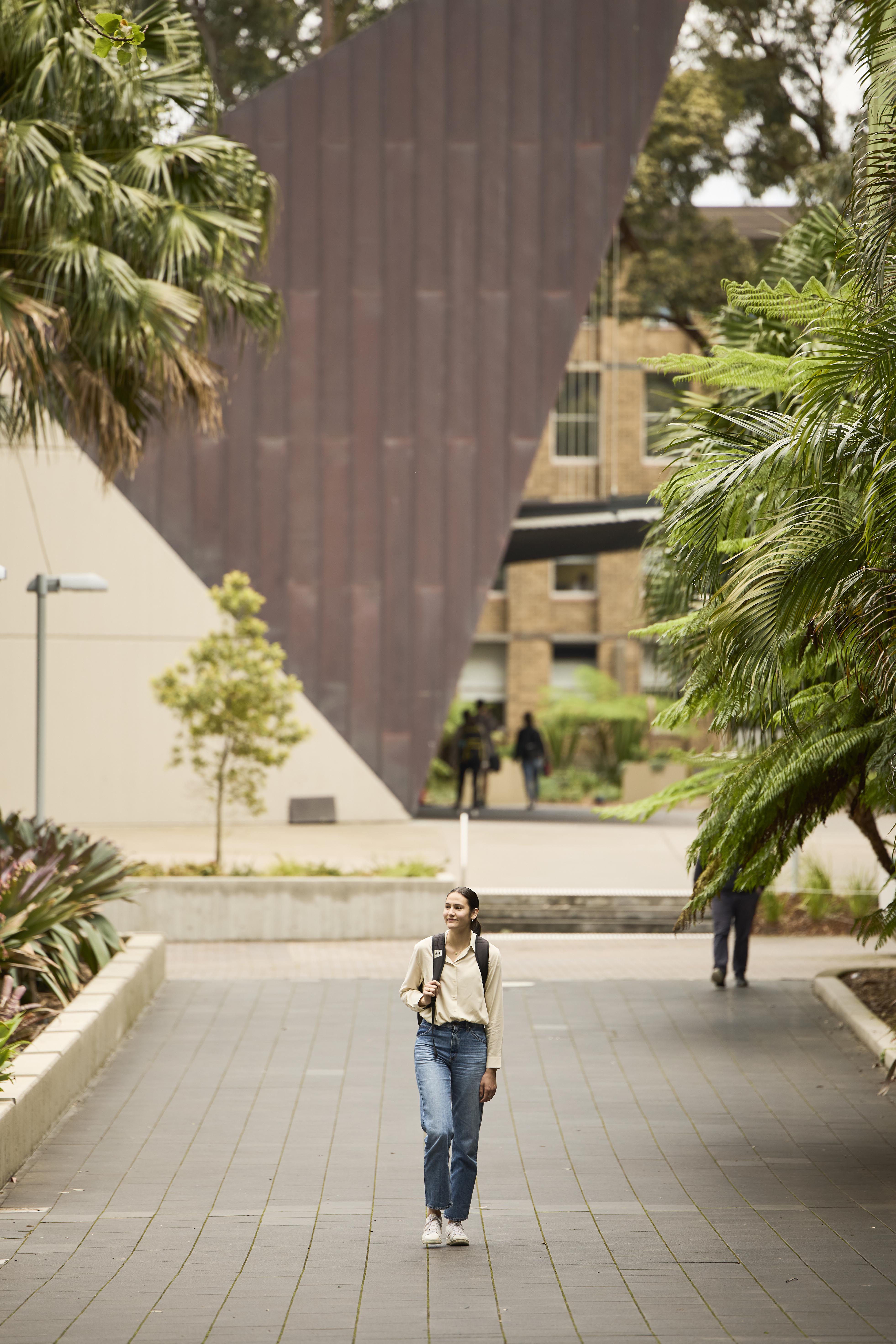 Sophie Fawns walking in the UNSW campus with a backpack on