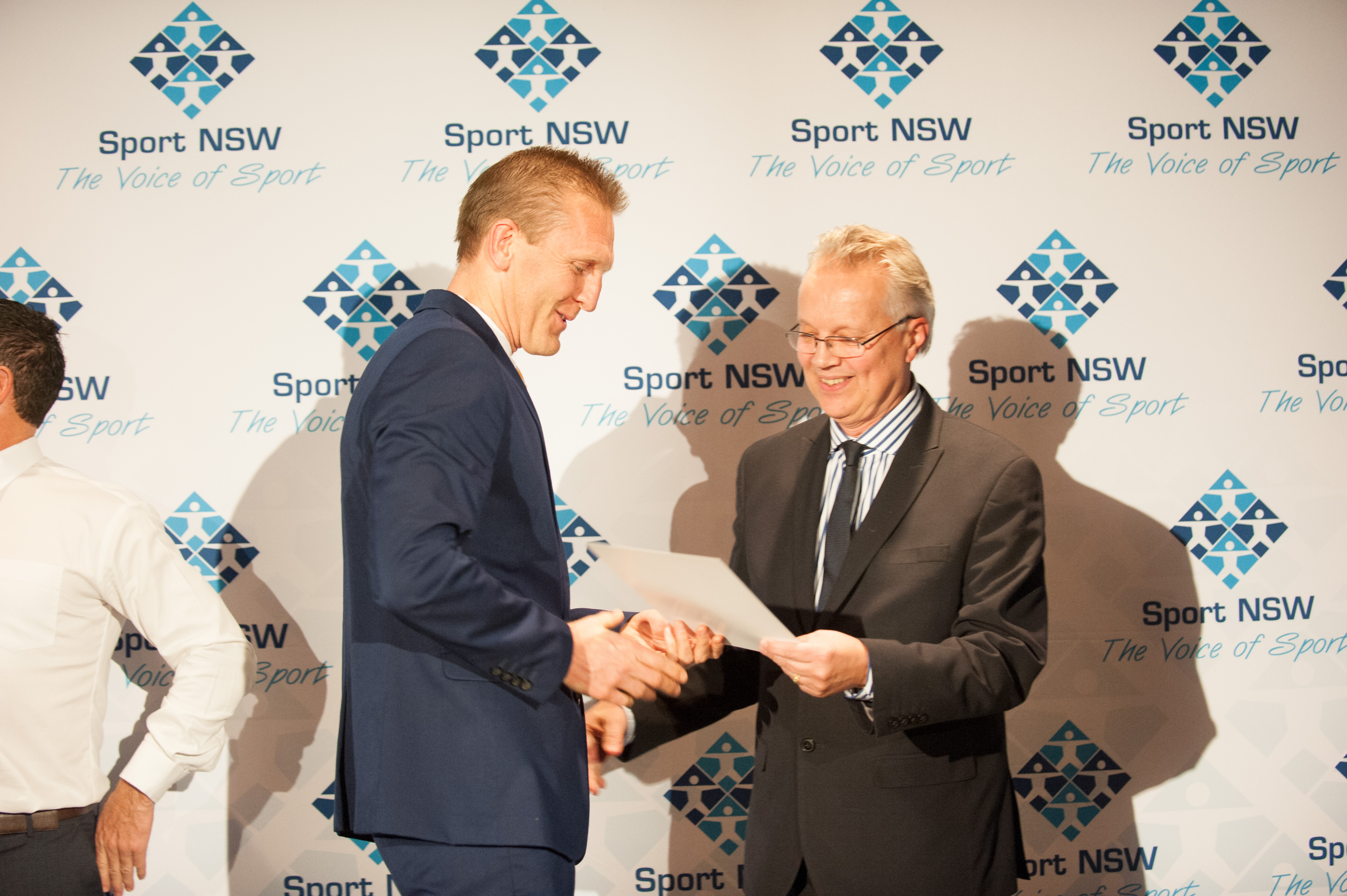UNSW Head of Sport Mark Wright presents the award to Killer Whales coach Tim Hamill