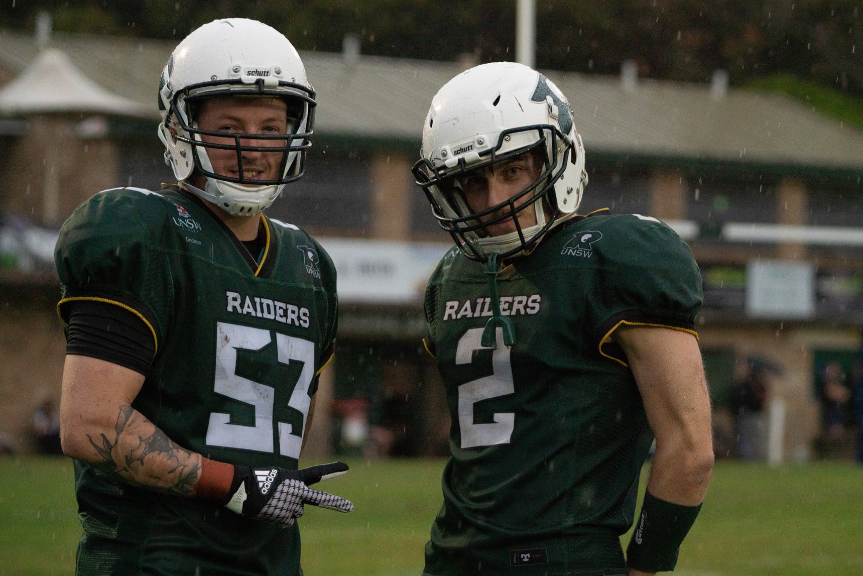 Two Raiders players standing in the rain
