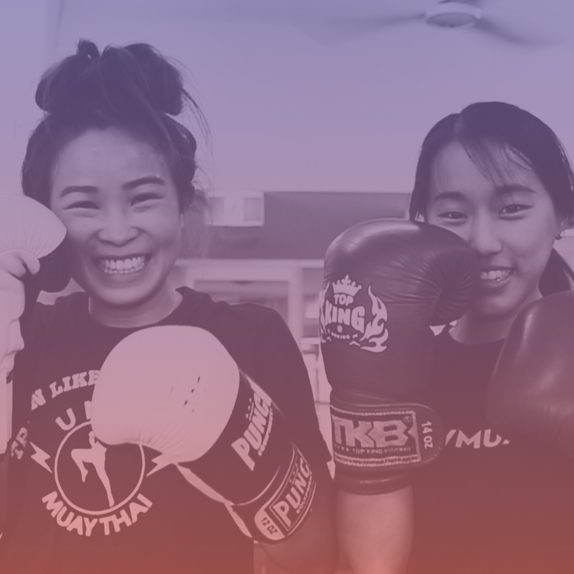 Women smiling with boxing gloves