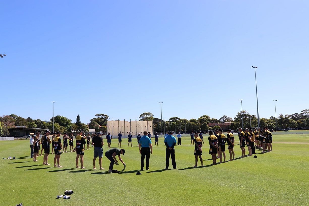 UNSW Cricket Club players forming a barefoot circle